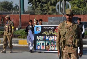 SCHOOL MASSACRE REMEMBERED  Pakistani students carry a banner bearing images of victims of the Peshawar school massacre as army troops cordon off a street leading to the Army Public School due to hold a ceremony to mark the first anniversary on December 16 of the massacre, which left more than 150 people dead, shocking a country already scarred by nearly a decade of attacks. AFP PHOTO