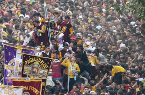 Religious Fervor Devotees clamber on each other to get near and touch the image of the Black nazarene. others threw towels to be wiped on the image as it wound through manila’s streets. Photo By Russel Palma