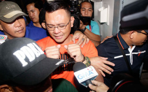 REVERSAL OF FORTUNE Marine Lt. Col. Ferdinand Marcelino is escorted by policemen to the Department of Justice. PHOTO BY CESAR DANCEL