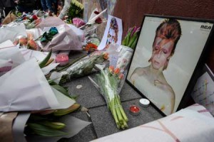 Tributes are seen beneath a mural of British singer David Bowie, following the announcement of Bowie’s death, in Brixton, south London, on January 11, 2016. British music icon David Bowie died of cancer at the age of 69, drawing an outpouring of tributes for the innovative star famed for groundbreaking hits like “Ziggy Stardust” and his theatrical shape-shifting style. AFP PHOTO