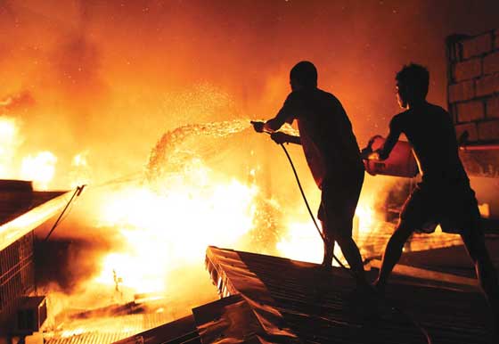 Residents help extinguish the fire that tore through a squatters’ area in Tondo, Manila. PHOTO BY CESAR DANCEL