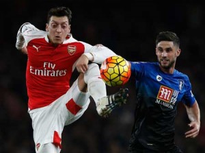 Arsenal’s German midfielder Mesut Ozil controls the ball in front of Bournemouth’s South African-born English midfielder Andrew Surman (right) during the English Premier League football match between Arsenal and Bournemouth at the Emirates Stadium in London on December 28, 2015. AFP PHOTO