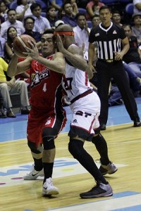 Vic Manuel of Alaska (No.4) attempts to drive the ball through the defense of Gabby Espinas of San Miguel Beer (No.27) in Game 2 of the PBA Philippine Cup best-of-seven finals at the Smart Araneta Coliseum in Quezon City on Tuesday. PHOTO BY CZEASAR DANCEL