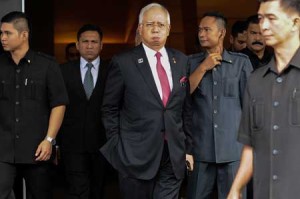 CLOSE CALL?  Malaysia’s Prime Minister Najib Razak (C) reacts as he walks towards his car after attending a parliament session in Kuala Lumpur on January 26. The Saudi royal family was the source of a $681 million “donation” that has engulfed Malaysian Prime Minister Najib Razak in scandal, his attorney general said in a statement clearing the premier of graft allegations. AFP PHOTO