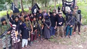 Members of the Abu Sayyaf Group (ASG) hoist black flags and shout after pledging allegiance to the Islamic State of Iraq and Syria (ISIS)