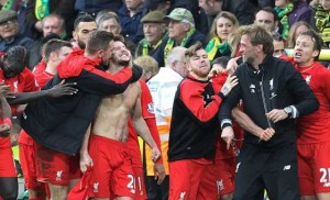 With his shirt off, Liverpool’s English midfielder Adam Lallana (center) celebrates scoring their late winning goal with teammates and Liverpool’s German manager Jurgen Klopp (second right) during the English Premier League football match between Norwich City and Liverpool at Carrow Road in Norwich, eastern England. AFP PHOTO 
