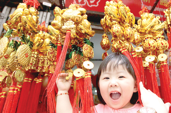  A child plays among dangling New Year decorations being sold at a stall in Binondo, Manila a week before the Chinese New Year, which has been declared a holiday. PHOTO BY CZEASAR DANCEL 