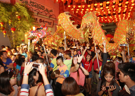  Spectators watch a dragon dance as the Chinese celebrate the start of the Year of the Monkey.  PHOTO BY RENE H. DILAN 