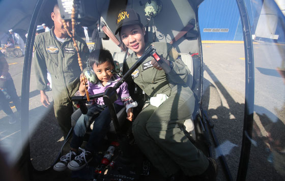 A little boy gets flying lessons from a soldier at Sangley Point in Cavite City where the Philippine Navy held its fly and sail program that allowed children and disabled persons ride helicopters and military vessels. Photo By Russell Palma    