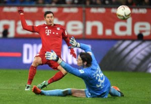 Bayern Munich’s Polish striker Robert Lewandowski (left) scores the second goal for Munich past Augsburg’s Swiss goalkeeper Marwin Hitz during the German first division Bundesliga football match of FC Augsburg vs FC Bayern Munich in Augsburg, southern Germany, on Monday. AFP PHOTO