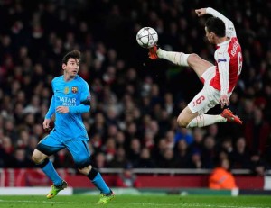 Barcelona’s Argentinian forward Lionel Messi (left) watches as Arsenal’s French defender Laurent Koscielny jumps to control the ball during the UEFA Champions League round of 16 1st leg football match between Arsenal and Barcelona at the Emirates Stadium in London on Wednesday. AFP PHOTO 
