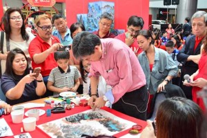 Dr. Alex Chan Lim doing an on-the-spot painting demonstration