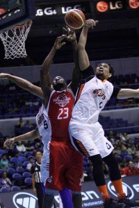 Andrew Adeleke of Phoenix battle for the rebound against Bryan Faundo of Meralco during the Philippine Basketball Association Commissioner’s Cup on Sunday at the Araneta Coliseum. CZAR DANCEL