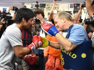 Manny Pacquiao (right) hits the mitts during training with coach Freddie Roach. AFP FILE PHOTO