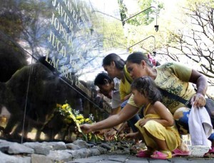 REMEMBER THEM  Relatives of those killed during the martial law years offer candles and flowers at the Bantayog ng mga Bayani on the eve of the 30th anniversary of the EDSA people power revolution. PHOTO BY MIKE DE JUAN