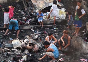 UP FROM THE ASHES residents salvage usable materials in the aftermath of a fire that destroyed hundreds of shanties in Barangay Balong Bato, Quezon City on thursday. at least 300 families were displaced by the two-hour blaze believed to have started from an unattended candle. PHOTO by RUy L. MARTInEZ