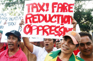 MAD DRIVERS  Taxi drivers rally at the LTFRB office in Quezon City to protest the reduction of cab fares. PHOTO by Mike De Juan 