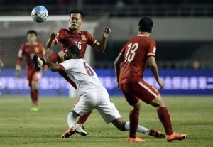 Huang Bowen (left) of China competes for the ball with Abdelaziz Hatim (center) of Qatar during their 2018 World Cup football qualifying match in Xi’an, northwest China’s Shanxi province on Wednesday. AFP PHOTO