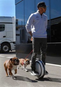 Mercedes AMG Petronas F1 Team’s British driver Lewis Hamilton uses a legway to walk his dogs at the paddock of the Circuit de Catalunya in Montmelo on the outskirts of Barcelona, on the test day of the Formula One Grand Prix season on March 1, 2016. AFP PHOTO