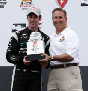 Simon Pagenaud receives the trophy for finishing second at the Firestone Grand Prix of Saint Petersburg in Florida that was won by teammate Juan Pablo Montoyta. INDYCAR.COM