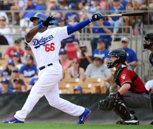 Yasiel Puig No.66 of the Los Angeles Dodgers hits a sacrifice fly ball driving in a run in the first inning against the Arizona Diamondbacks during the spring training game at Camelback Ranch on March 5, 2016 in Glendale, Arizona. AFP PHOTO 