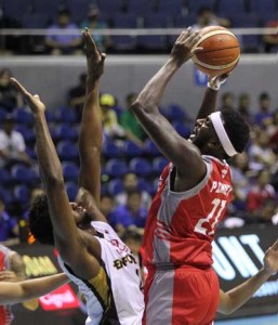 AERIAL COLLISION Kevin Pinkney no.21 of Phoenix attempts a shot through the guard of Augustus Gilchrist No.0 of Mahindra during a PBA Commissioner’s Cup game at the Smart Araneta Coliseum in Quezon City on Wednesday. PHOTO BY CZEASAR DANCEL