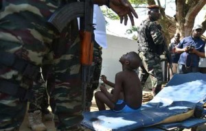 A wounded child is surrounded by Ivorian security forces after heavily armed gunmen opened fire on March 13, at a hotel in the Ivory Coast beach resort of Grand-Bassam. AFP PHOTO