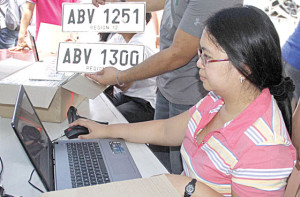 BRANd NEW  A personnel of the land transportation office scans the license plates. PHoto By Mike De Juan