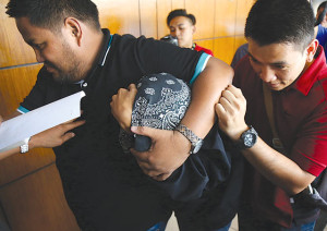 GAME OVER NBI agents from the Anti-Cyber Crime Division escort the suspect responsible for the hacking of Comelec’s database. PHOTO BY RENE H. DILAN 