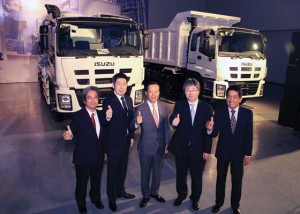 IPC executives posing with some of the Isuzu trucks on display.