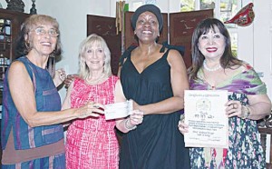  Sarah Tockes and Michelle Washington (center) turnover the remaining monetary assets of MMQ to EVA Foundation’s Jenny Wallum and Bing Carrion (extreme left and right).   Photo by Abby Palmones