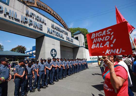 A phalanx of policemen guards the gate of Camp Crame to stop members of militant groups from entering the police headquarters. The protest rally was held to condemn the shooting of farmers in Kidapawan City last week. PHOTO BY RUY MARTINEZ