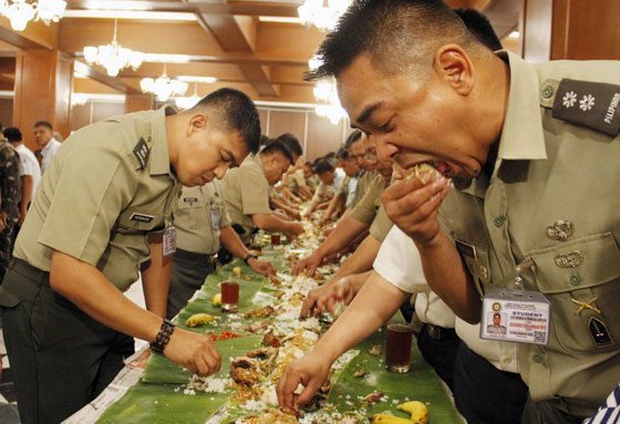 Philippine Army servicemen and non uniformed personnel join in a boodle fight at Camp Aguinaldo to celebrate the peaceful and orderly elections last Monday. PHOTO BY MIKE DE JUAN 