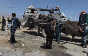 Afghan security personnel stand near damaged vehicles at the scene of a suicide bomb attack in Paghman district in Kabul on May 25. AFP PHOTO