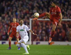 Liverpool’s Emre Can (right) jumps for a kick during the match against Augsburg at Anfield on February 25, 2016. AFP PHOTO