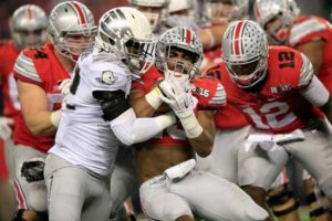 Running back Ezekiel Elliott (center) of the Ohio State Buckeyes runs the ball against the Oregon Ducks during their College Football Playoff National Championship Game, at AT&T Stadium in Arlington, Texas, on January 12, 2015.  AFP FILE PHOTO 