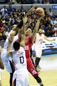 DOUBLE TROUBLE Alaska’s forward Tony Dela Cruz fires a jump shot against the defense of Meralco’s center Arinze Onuaku and forward Bryan Faundo in Game 4 of the PBA Commissioner’s Cup semifinals at the Smart Araneta Coliseum in Quezon City on Monday. PHOTO BY CZEASAR D
