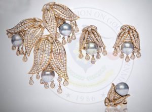  Cultured pearl and diamond earclip, brooch and ring in yellow gold— price equivalent to the annual income of 15 Filipinos