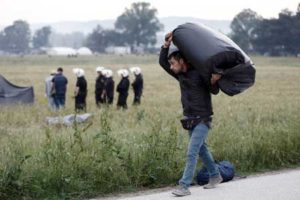 A refugee man carries his belongings during an evacuation operation by police forces of a makeshift migrant camp at the Greek-Macedonian border near the village of Idomeni, on May 24. AFP/POOL/Yannis KOLESIDIS