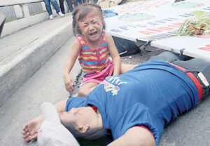 REAL TRAUMA A child too young to understand the concept of a drill breaks down upon seeing her mother “pinned” by a billboard during the second annual quake drill held in Makati City on Wednesday. PHOTO BY MIKE DE JUAN 