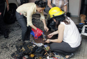 TRAPPED Grace Rafanan (with safety hat) and two other relatives sort out the belongings of her mother Marilyn, wife of retired General Ismael Rafanan, who died along with her daughter sarah after they were trapped in a fire that gutted their house in Capitol estates in Quezon City. Photo by Mike De Juan 