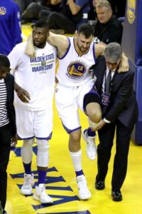 Andrew Bogut No.12 of the Golden State Warriors is assisted off the court after sustaining an injury during the third quarter against the Cleveland Cavaliers in Game 5 of the 2016 NBA Finals at ORACLE Arena on Tuesday in Oakland, California. AFP PHOTO