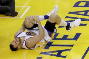 Andrew Bogut No.12 of the Golden State Warriors holds his knee in pain after sustaining an injury during the third quarter against the Cleveland Cavaliers in Game 5 of the 2016 NBA Finals at ORACLE Arena on Tuesday in Oakland, California. AFP PHOT