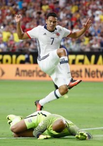 Carlos Bacca (No. 7) of Colombia leaps over goalkeeper Tim Howard of US after a shot attempt during the first half of the 2016 Copa America Centenario third place match at University of Phoenix Stadium in Glendale, Arizona.  AFP PHOTO