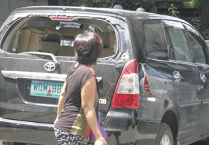 DEATH CAR A passerby looks at the bullet-riddled vehicle of Senior Inspector Ramon Castillo who was killed in an anti-drug operation on Tuesday. PHOTO BY MIKE DE JUAN 