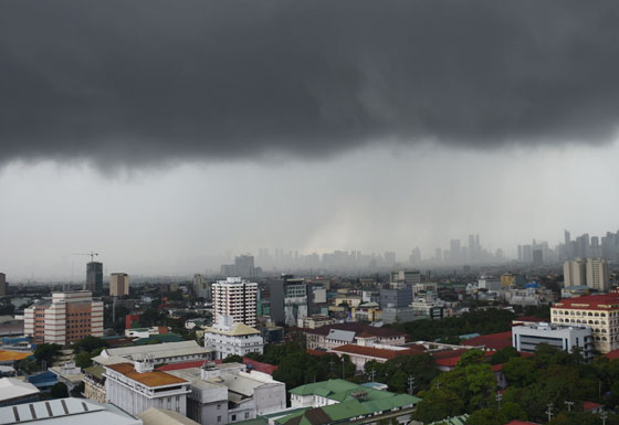 Black rain clouds gather above buildings in Manila Monday. The weather bureau warned that the southwest monsoon will bring more rain in Luzon. AFP PHOTO 