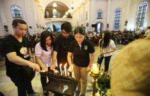 MASS COMFORT Members of Huwag Kang Papatay Movement light candles during a Mass for victims of extrajudicial killings. PHOTO BY RUSSELL PALMA 