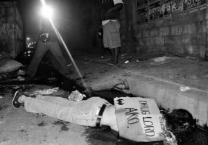 EDITORS NOTE: Graphic content / The dead body of a suspected drug dealer lies on the ground with a placard reading 