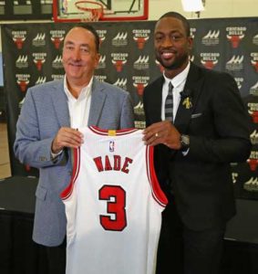 General manager Gar Forman of the Chicago Bulls (left) presents new Bull Dwyane Wade with his jersey at an introductory press conference at the Advocate Center on Saturday in Chicago, Illinois. AFP PHOTO
