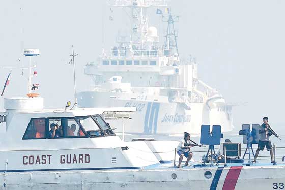 Philippine Coast Guard personnel pose as pirates aboard their boat while Japanese Coast Guard ship PLH02 Tsugaru steams toward them during the Philippine-Japanese joint anti-piracy exercise off Manila Bay on Wednesday, a day after a UN-backed tribunal declared China has no “historic rights” in the West Philippine Sea. AFP PHOTO